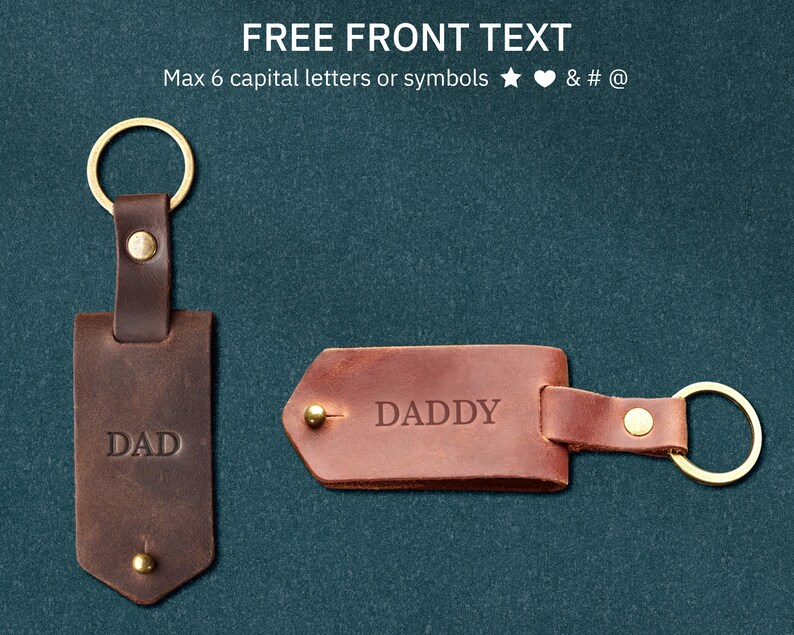 May include: Two brown leather keychains with gold rings. The keychain on the left says "DAD" and the keychain on the right says "DADDY".