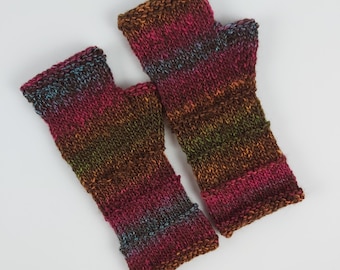 May include: A pair of fingerless gloves in a brown, pink, and blue color scheme with a striped pattern.