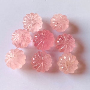 Pu&ograve; includere: Otto cabochon di quarzo rosa con un designo a fiore intagliato. I cabochon sono lisci e lucidi.