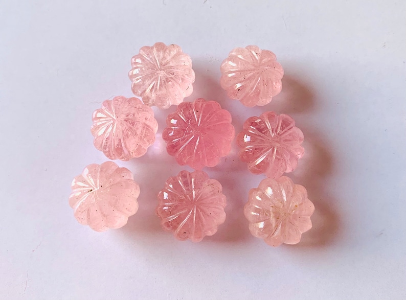 Pu&ograve; includere: Otto cabochon di quarzo rosa con un designo a fiore intagliato. I cabochon sono lisci e lucidi.
