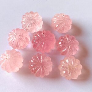 Pu&ograve; includere: Otto cabochon di quarzo rosa con un designo a fiore intagliato. I cabochon sono lisci e lucidi.
