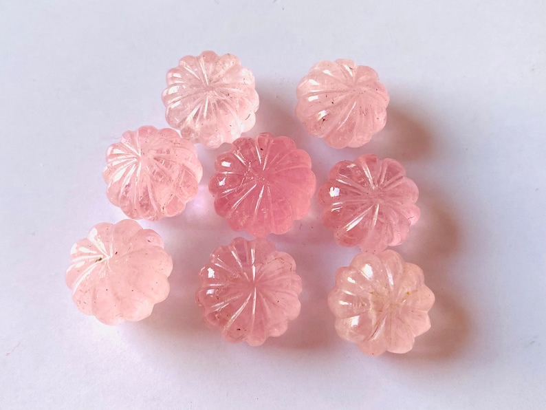 Pu&ograve; includere: Otto cabochon di quarzo rosa con un designo a fiore intagliato. I cabochon sono lisci e lucidi.