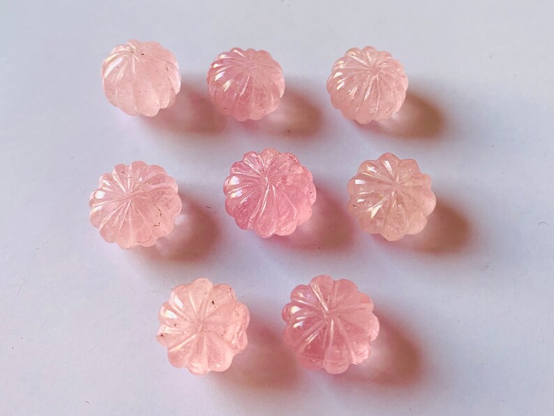 Pu&ograve; includere: Otto perle di quarzo rosa rosa con un motivo floreale intagliato. Le perle sono lisce e lucidate.