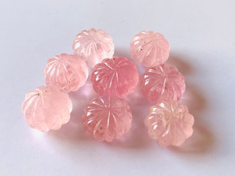 Pu&ograve; includere: Otto cabochon di quarzo rosa con un designo a fiore intagliato. I cabochon sono lisci e lucidi.