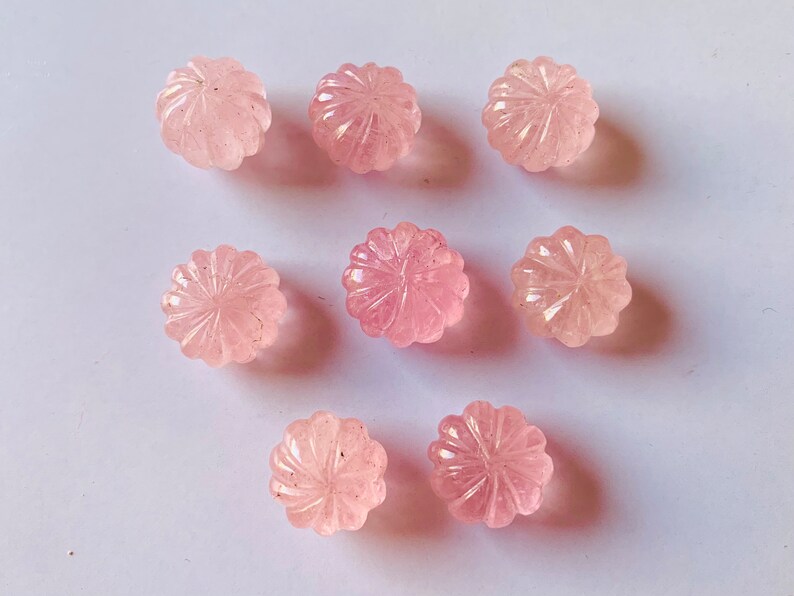 Pu&ograve; includere: Otto cabochon di quarzo rosa con un designo floreale intagliato. I cabochon sono lisci e lucidi.
