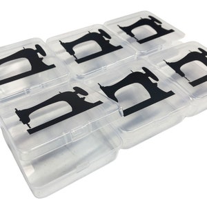 K&ouml;nnte beinhalten: Sechs transparente Kunststoff-Aufbewahrungsboxen mit schwarzen N&auml;hmaschinen-Silhouetten auf den Deckeln. Die Boxen sind ideal zum Organisieren von N&auml;hzubeh&ouml;r.