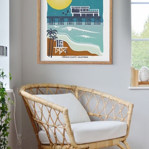 May include: A retro-style illustration of the Newport Beach pier with a lifeguard stand, palm trees, and a full moon. The text "Newport Beach" is in a stylized font with stars on either side. The text "Orange County, California" is at the bottom of the illustration.