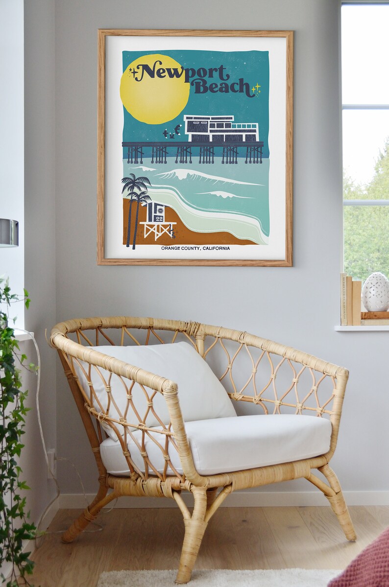 May include: A retro-style illustration of the Newport Beach pier with a lifeguard stand, palm trees, and a full moon. The text "Newport Beach" is in a stylized font with stars on either side. The text "Orange County, California" is at the bottom of the illustration.