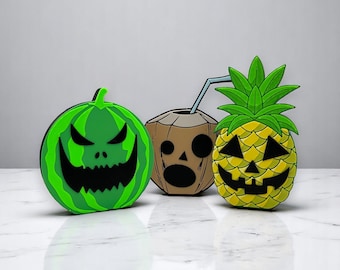 May include: Three Halloween-themed decorations: a green watermelon with a scary face, a brown coconut with a straw and a face, and a yellow pineapple with a scary face.