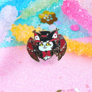 May include: A black and white cat with red wings and a top hat. The cat has yellow eyes and a red bow tie. The wings are decorated with red and white hearts. The cat is on a pink background.