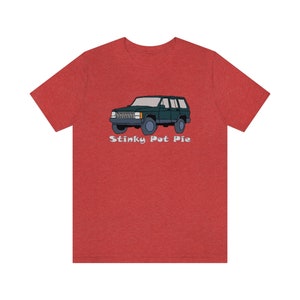Puede incluir: Camiseta roja jaspeada con una ilustración de dibujos animados de un Jeep verde y el texto "Stinky Pot Pie" en blanco.