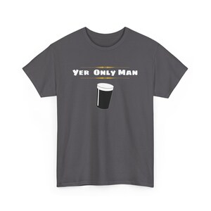 May include: A dark gray t-shirt with the text "Yer Only Man" in white letters and a black and white illustration of a pint glass.