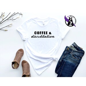 May include: White t-shirt with black text that reads "COFFEE & dissertation".