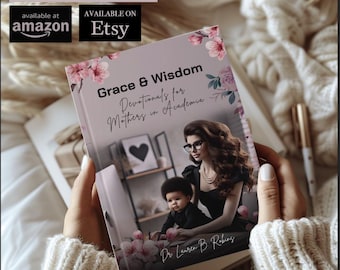 May include: A pink and white book titled "Grace & Wisdom Devotional for Mothers in Academia" by Dr. Lauren B. Robins. The book cover features a woman with dark hair and glasses holding a young child.
