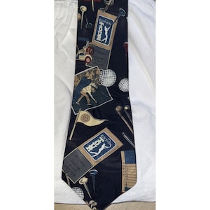 May include: A navy blue golf-themed necktie featuring golf balls, tees, and a golfer in action. The tie has a repeating pattern of golf-related imagery, including a golf cart and the text "HOOD EDITION".