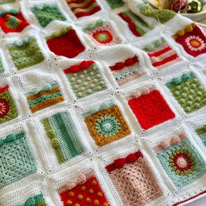 May include: A white crochet blanket with a variety of colorful squares featuring different Christmas gift designs. The squares are made with different stitches and textures, including polka dots, stripes, and flowers.