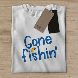 Peut inclure: T-shirt blanc avec le texte bleu "Gone fishin'" et un petit graphique de leurre de pêche.