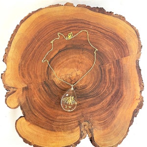 Ethically sourced moth encased in clear resin with gold and silver flakes teardrop shape gold necklace