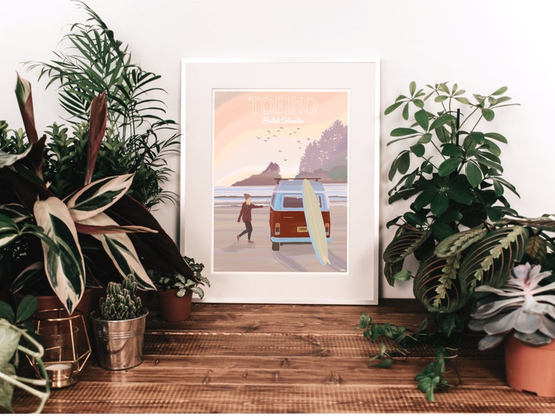 Op de afbeelding: Een vintage poster met een zonsondergangsc&egrave;ne van een strand met een rood-witte bus en een persoon die een surfboard vasthoudt. De poster heeft de tekst "TOFINO" en "British Columbia" erop.