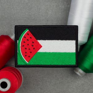 May include: Embroidered patch featuring a watermelon slice design over the Palestinian flag. The patch has a black border, with a red, white, green, and black color scheme. The watermelon slice is red with black seeds.