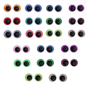 May include: A collection of colorful, glittery craft eyes in various shades, including orange, blue, red, green, silver, pink, and purple. Each eye has a black pupil and a white ring. These are ideal for crafting and doll making.