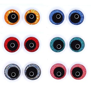 Peut inclure: Une collection de huit paires d'yeux artisanaux scintillants de diff&eacute;rentes couleurs. Les yeux ont un centre noir avec un contour blanc et sont entour&eacute;s de paillettes orange, bleu, rouge, vert, argent et rose.