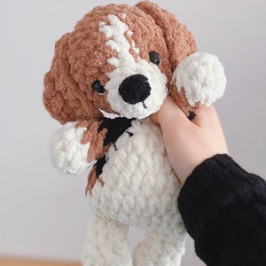 May include: Crochet amigurumi pattern for a brown and white dog with black eyes and nose. The pattern is available in English and is a PDF file.