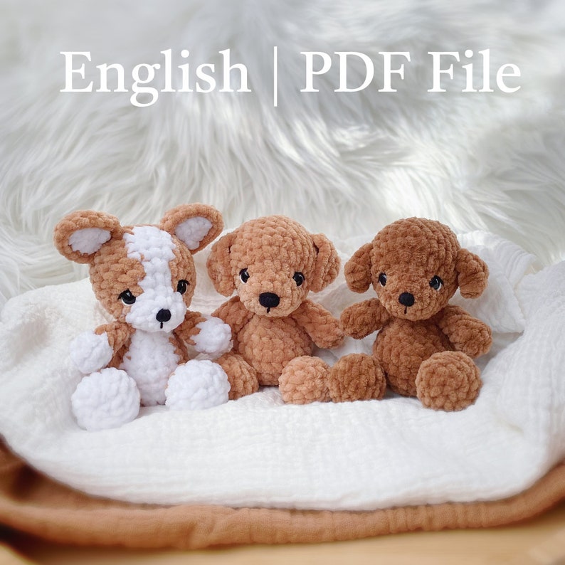 May include: Three crocheted plush toys, a white and brown dog, and two brown teddy bears, are sitting on a white and brown blanket. The image includes the text "English | PDF File".