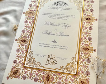 Może przedstawiać: Ozdobny akt ślubu ze złotymi i różowymi wzorami kwiatowymi. Dokument zawiera nazwiska "Mohamed Zaheer" i "Fathima Shimra" oraz tekst w języku angielskim i arabskim. Certyfikat jest oprawiony w złotą ramkę.