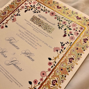 Pu&ograve; includere: Un certificato di matrimonio con un bordo floreale ornato in tonalit&agrave; di rosa, oro e verde. Il testo recita "Questo accordo, stipulato il 12 aprile 2025, corrispondente al 13 Shawwal 1446 AH nella citt&agrave; di Edison, NJ, certifica il matrimonio di Ihman e Yosa Ghauri."