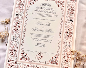 May include: A traditional Islamic marriage certificate with ornate floral borders in shades of pink and brown. The text reads "This agreement is to certify that the marriage of Amir Ali & Mariam Khan has been solemnised in accordance to the requirements of Islamic Law, as enshrined in the Holy Quran and the Sunnah of Prophet Muhammad (SAW)." The date of the marriage is January 16, 2025, Rejab 16, 1446H, Mississauga, Canada.