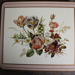 K&ouml;nnte beinhalten: Ein quadratischer Platzdeckchen mit floralem Design. Das Bild zeigt einen Strau&szlig; aus Rosen, Tulpen und anderen Blumen in Rosa-, Wei&szlig;- und Burgundert&ouml;nen. Der Platzdeckchen hat einen cremefarbenen Hintergrund mit einem rosa Rand.