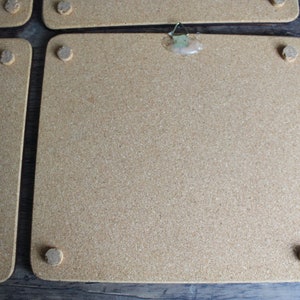 K&ouml;nnte beinhalten: Eine Sammlung rechteckiger Korktafeln mit abgerundeten Ecken. Jede Tafel hat kleine, kreisf&ouml;rmige Korkf&uuml;&szlig;e. Eine Tafel hat einen Metallb&uuml;gel, der mit Klebstoff befestigt ist.