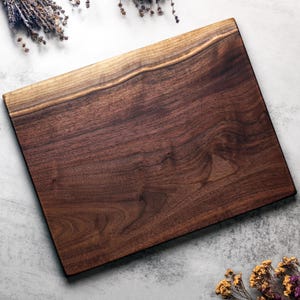 Premium hardwood cutting board made from a single slab of walnut, cherry, or maple. No stains, glues, or dyes—just natural wood beauty. Available in three sizes with custom engraving options.