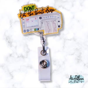 May include: A white and yellow badge reel with a cartoon image of a heart monitor. The text on the badge reel says "Don't let the beat drop".