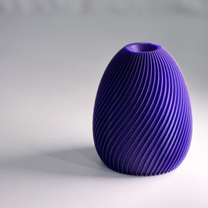 May include: A purple, 3D printed vase with a swirling, textured design.