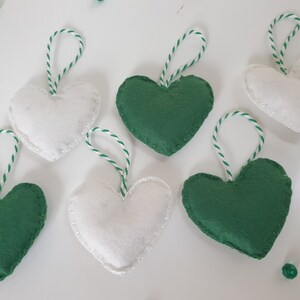 May include: Six felt heart ornaments, three green and three white, with white twine attached to each.