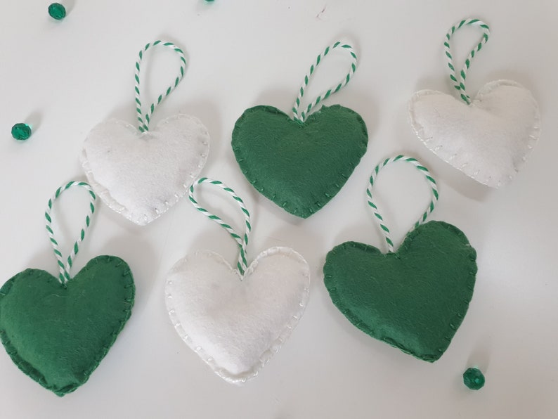 May include: Six felt heart ornaments, three green and three white, with white twine attached to each.