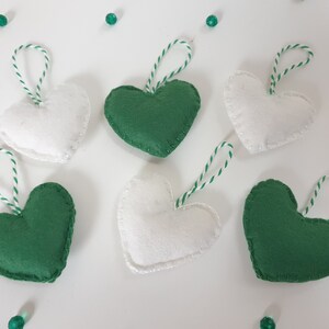 May include: Six felt heart ornaments, three green and three white, with twine hangers.