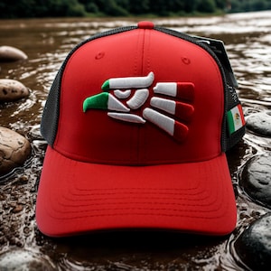 May include: A red baseball cap with a black mesh back and a curved brim. The cap features a white, green, and red emblem of an eagle. A small Mexican flag is attached to the side.