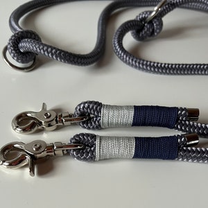 May include: Two gray rope leashes with silver clips and a silver ring. The leashes are striped with white and navy blue.