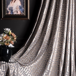 May include: Gray patterned curtain with a geometric design. The curtain is made of a soft, luxurious fabric and has a subtle sheen.