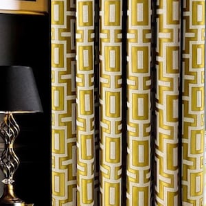 May include: Gold curtains with a geometric pattern of squares and rectangles. The curtains are made of a textured fabric and have a subtle sheen.