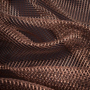 Pode incluir: Close-up de um tecido texturizado, tecido em tons de castanho e cobre. O material tem um padr&atilde;o de grade com um brilho sutil, criando uma sensa&ccedil;&atilde;o de profundidade e dimens&atilde;o. O tecido &eacute; drapeado, mostrando dobras e curvas suaves.