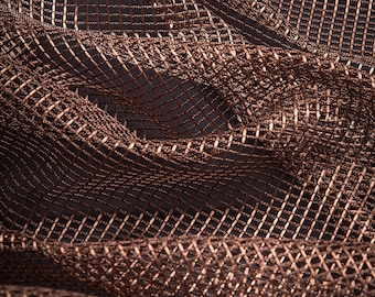 Pode incluir: Close-up de um tecido texturizado, tecido em tons de castanho e cobre. O material tem um padrão de grade com um brilho sutil, criando uma sensação de profundidade e dimensão. O tecido é drapeado, mostrando dobras e curvas suaves.