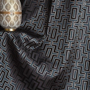 May include: Green fabric with a black geometric pattern. The fabric has a subtle sheen and a luxurious feel.
