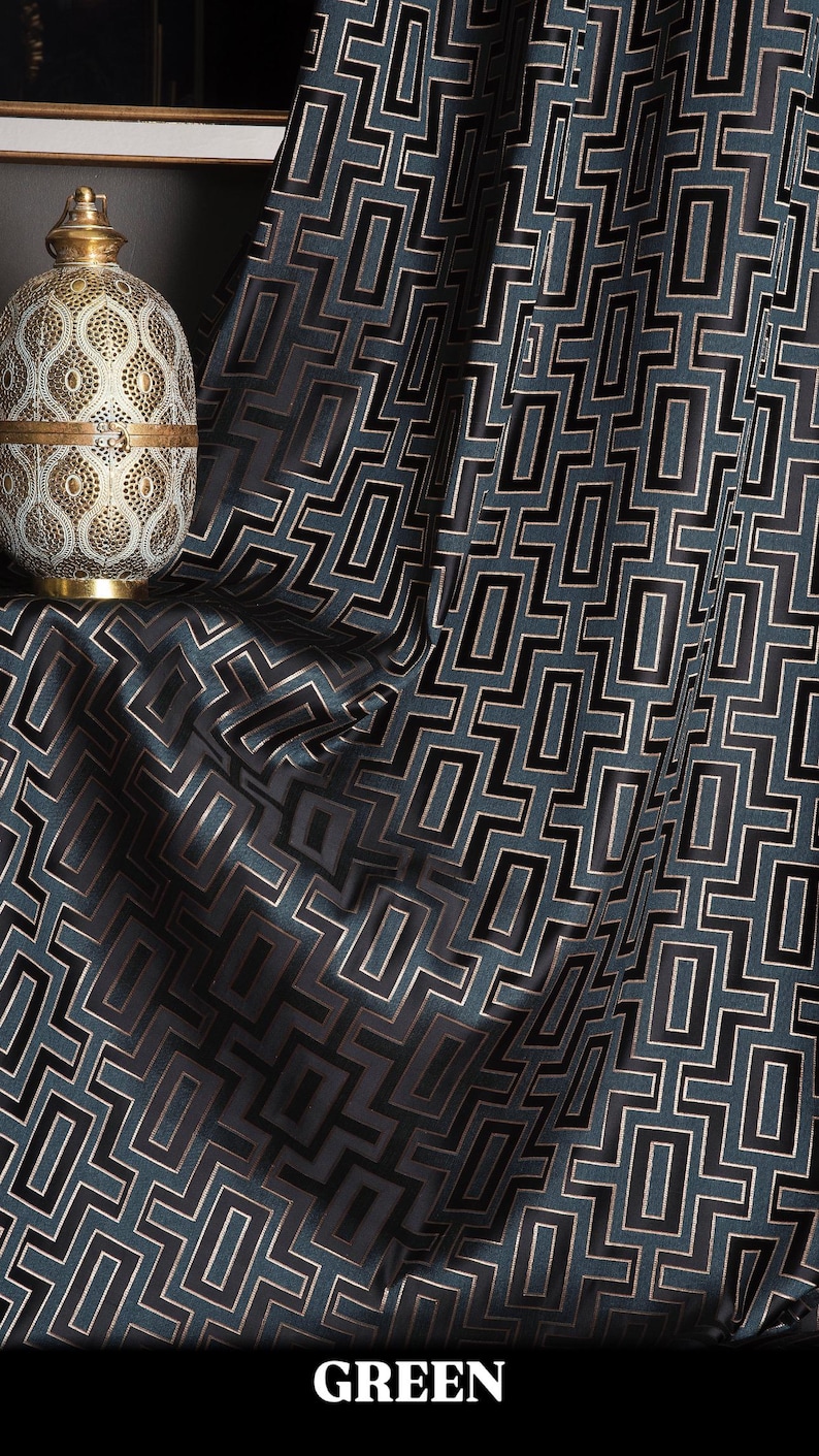 May include: Green fabric with a black geometric pattern. The fabric has a subtle sheen and a luxurious feel.