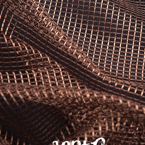 Pode incluir: Close-up de um tecido cor de cobre com um padr&atilde;o em forma de grade. O material est&aacute; drapeado, criando sombras e destaques. A palavra "COPPER" est&aacute; escrita em branco na parte inferior da imagem.