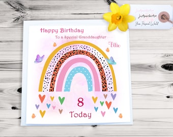May include: A pink and white birthday card with a rainbow design featuring a leopard print pattern. The card says "Happy Birthday To a Special Granddaughter" and "Ellie" with the number "8" and the word "Today".