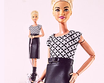 May include: Two dolls with blonde hair styled in an updo, wearing a black and white checkered short-sleeved top, a black belt with a silver buckle, and a black skirt. One doll holds a thin pink leash attached to a small white dog figurine.
